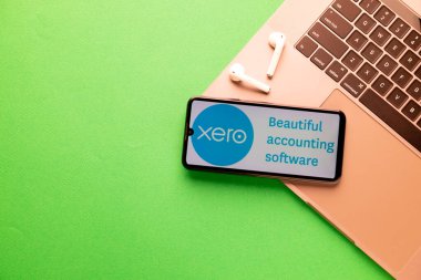 Kyoto Şehri, Japonya - 31 Temmuz 2023: Xero yeşil arka planda modern bir dizüstü bilgisayarın yanında sergilendi