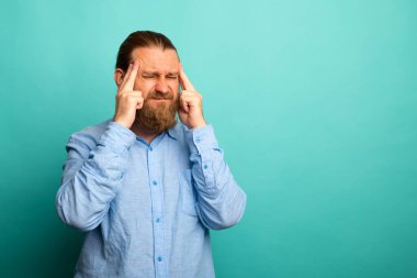 Seçkin sakallı yaşlı bir adam. Tecrit edilmiş bir geçmişi var. Başı ağrıyor çünkü stres altında. Migren ağrısı..