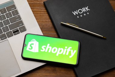 Kyoto Şehri, Japonya - 31 Temmuz 2023: Ahşap arka planda Shopify logosu olan Apple iPhone