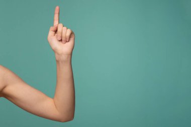 Kadınlar mavi arkaplanda el işaretleri oluşturur