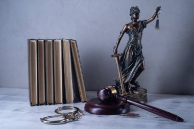 Bayan Adalet, Yargıç 'ın tokmağı, kitaplar, eski ahşap bir masada kelepçeler.