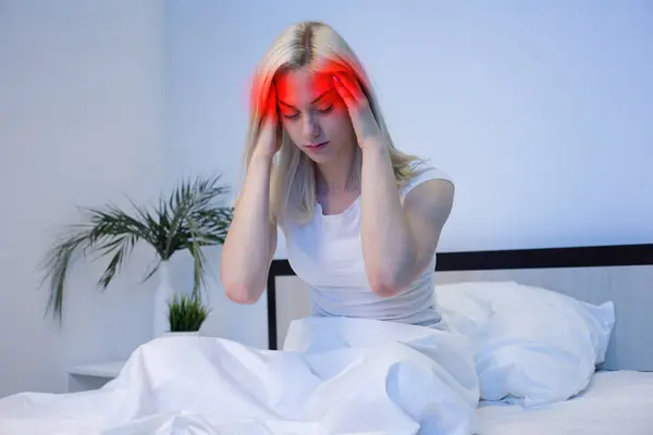 stock image Young Woman in bad with hand on head for pain in head. Suffering migraine.