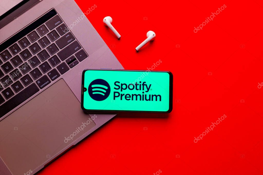 Kyoto city, Japan - July 31, 2023: Logo Spotify on a smartphone near modern laptop on red background