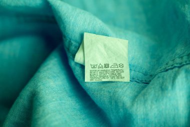 Clothing label on light green garment, top view