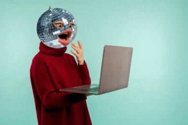 Soyut modern kolaj. Kafası ve ağzı süveteri olan ve mavi arka planda dizüstü bilgisayar ekranı olan bir kadın yerine aynalı disko topu olan bir kadın.