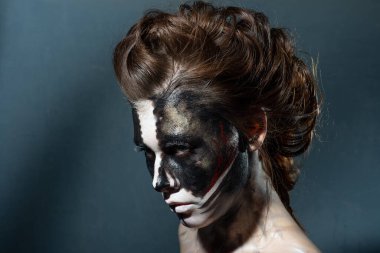 Stüdyo fotoğrafında cadılar bayramı makyajı yapılıyor.