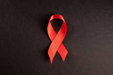 Kırmızı kurdele HIV, siyah arka planda AIDS, farkındalık, tıbbi işaret. Boşluğu kopyala.