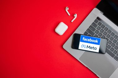 Tula, Rusya - Kasım 19, 2021: Logo Meta ve Facebook kırmızı arka planda modern bir dizüstü bilgisayarın yanında sergileniyor