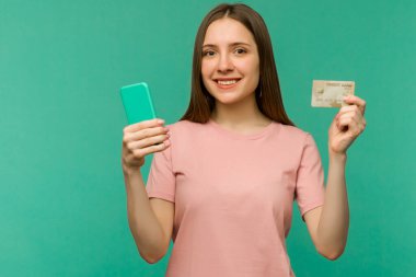 Mutlu çığlık atan genç bir kadının fotoğrafı cep telefonu kartı kullanarak mavi duvar arkasında izole bir şekilde poz veriyor. - Görüntü