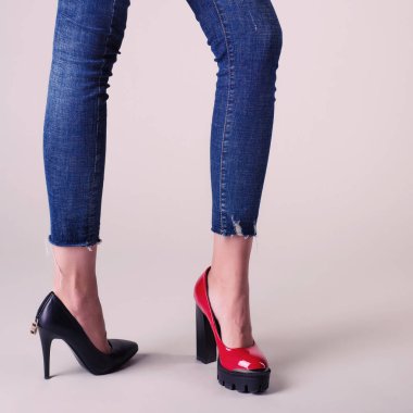 Tarafsız arka planda izole edilmiş yaz ayakkabılı kadın bacakları. çift konseptini seç - kırmızı veya siyah ayakkabılar.