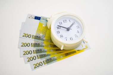 Retro tarzı çalar saat. Euro nakit para beyaza izole edilmiş. Zaman para kavramıdır.