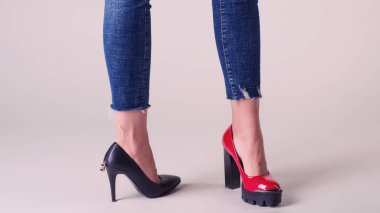 Tarafsız arka planda izole edilmiş yaz ayakkabılı kadın bacakları. çift konseptini seç - kırmızı veya siyah ayakkabılar.