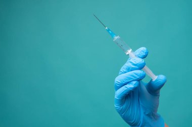 Doktorun elinde şırınga, aşı.