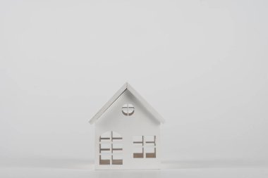 Minyatür oyuncak evi beyaz arka planda izole edilmiş basit bir tasarım. Konut kredisi sigortası hayali ev konsepti