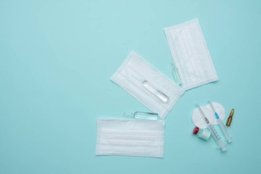 Şırınga, maske, mavi arka planda ampul, aşı konsepti.