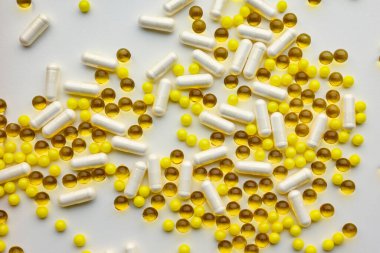 Beyaz arka planda kapsül ve haplar şeklinde biyolojik olarak aktif katkı maddeleri