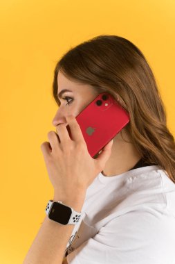 Tula, Rusya - 23 Eylül 2020: Yeni model iPhone ve elma saatiyle akıllı telefondan konuşan güzel genç kadın.