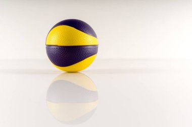 Beyaz arka planda sarı ve mor lekeli basketbol topu. Stres önleyici top