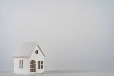 Minyatür oyuncak evi beyaz arka planda izole edilmiş basit bir tasarım. Konut kredisi sigortası hayali ev konsepti