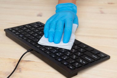 Covid-19 ofis alanını temizliyor Corona virüsünü temizliyor ve çalışma alanınızı dezenfekte ediyor. Masa, klavye ve fare yüzeyi silmek için mendiller dezenfekte ediliyor.