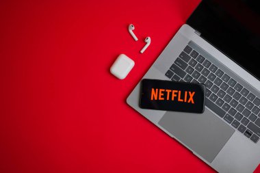 Tula, Rusya - Kasım 19, 2021: Logo Netflix kırmızı arka planda modern bir dizüstü bilgisayarın yanında sergilendi