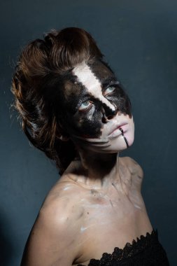 Stüdyo fotoğrafında cadılar bayramı makyajı yapılıyor.