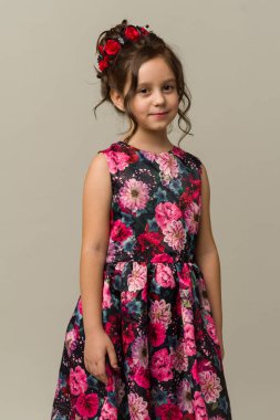 Gri arka planda izole edilmiş gülümseyen küçük kız çocuğunun fotoğrafı. Kameraya bak.