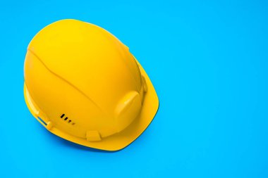 Mavi arka planda sarı inşaat kaskı