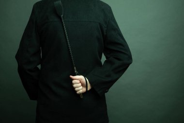 Erkek egemen elinde deri kamçı tutuyor. Sert BDSM seksi için şaplak atıyor.
