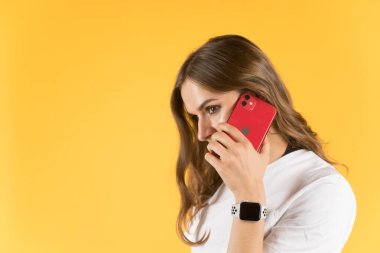 Tula, Rusya - 23 Eylül 2020: Yeni model iPhone ve elma saatiyle akıllı telefondan konuşan güzel genç kadın.