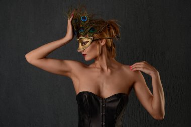 Siyah deri korse ve Venedik maskeli güzel bir kadının portresi