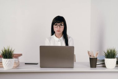 Evde bilgisayarla çalışan mutlu ve serbest bir genç kadın. Çevrimiçi öğrenim gören çekici iş kadını, dizüstü bilgisayar, web sörfü bilgileri veya internet mağazasından alışveriş yapıyor..