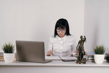 Ofisinde ya da uzaktan çalışan genç bir kadın avukat..