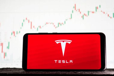 Tula, Rusya - 10 Ağustos 2020: Borsa eğilimlerinin arka planına karşı akıllı telefon üzerindeki logo Tesla.