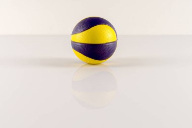 Beyaz arka planda sarı ve mor lekeli basketbol topu. Stres önleyici top