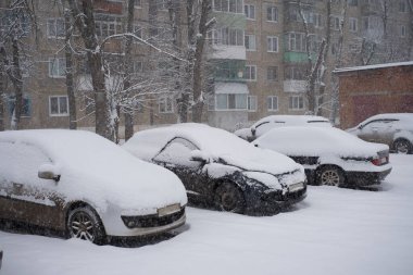 Otoparkta karla kaplı arabalar..