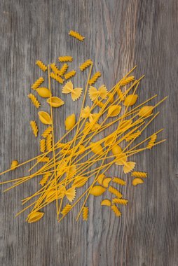 Üst manzara ahşap zemin üzerinde çeşitli İtalyan makarnaları