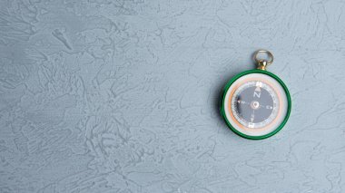 Pusula ile turizmin sembolü olarak gri arka planda klasik yuvarlak pusula, pusula ile seyahat ve pusula ile açık hava aktiviteleri