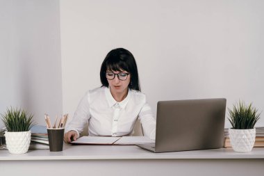 Evde bilgisayarla çalışan mutlu ve serbest bir genç kadın. Çevrimiçi öğrenim gören çekici iş kadını, dizüstü bilgisayar, web sörfü bilgileri veya internet mağazasından alışveriş yapıyor..