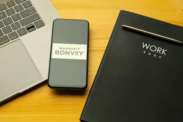 stock image Kyoto city, Japan - July 31, 2023: Marriott International Bonvoy displayed on a smartphone near modern laptop on wooden background