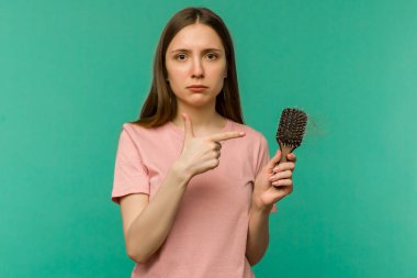 Mavi arka planda taraklı ve sorunlu saçlı genç kız - görüntü