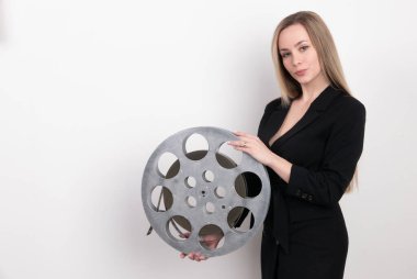 A young woman movie executive is holding an old film reel clipart