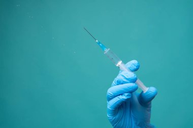 Doktorun elinde şırınga, aşı.