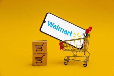 Kyoto Şehri, Japonya - 12 Ağustos 2024: Sarı arka plandaki oyuncak market arabasında akıllı telefon ekranında Walmart logosu.