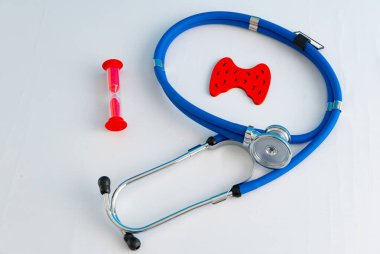 Anatomik model insan tiroidi bezi kum saati ve stetoskop ile yakın plan.