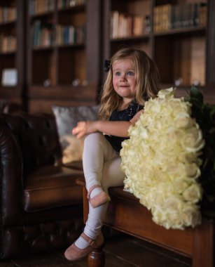 portrait of a happy litlle girl with big bouquet of flowersin in