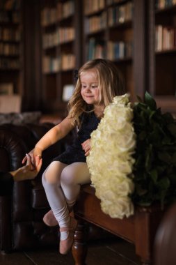 portrait of a happy litlle girl with big bouquet of flowersin in