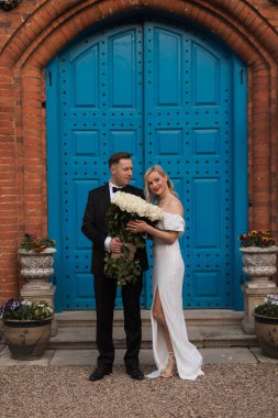Romantic groom looking to the beautiful bride near old big casle