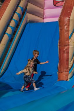 Kids having fun and sliding and jumping on outdoor playground. K