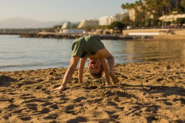 Little boy doing a handstand on the beach.Summer recreation and 